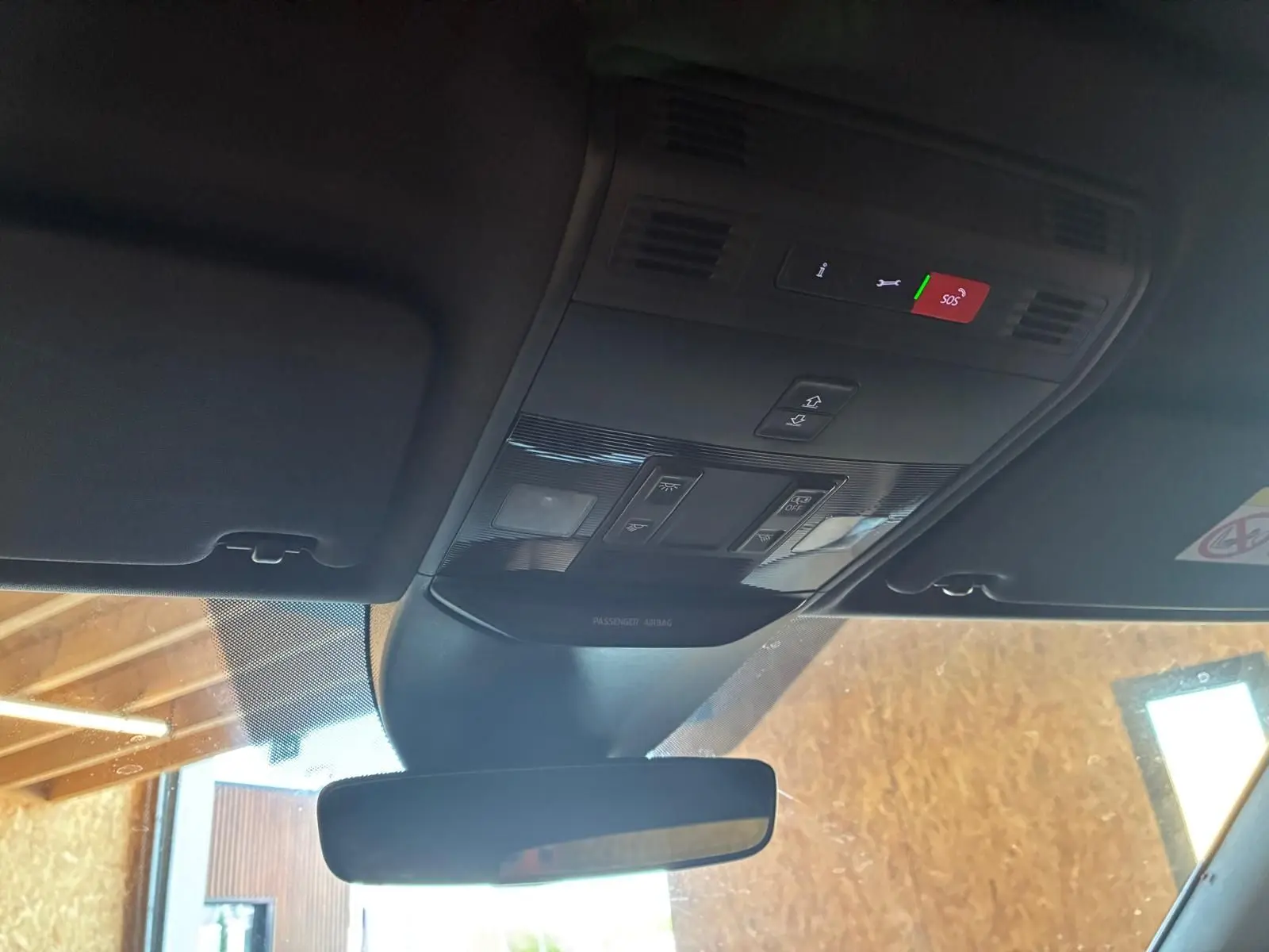 Vue intérieure du plafond avant d'une Skoda Kamiq 2024 gris foncé, avec commandes d'éclairage et rétroviseur central visible.
