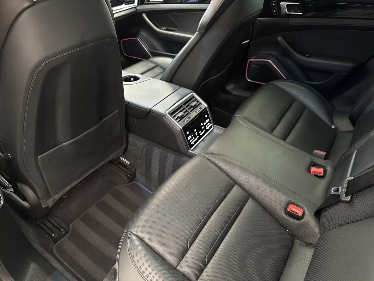 Vue intérieure arrière côté droit de la Porsche Panamera 4 E-Hybrid Sport Turismo 2018, sièges cuir noirs et console centrale tactile.
