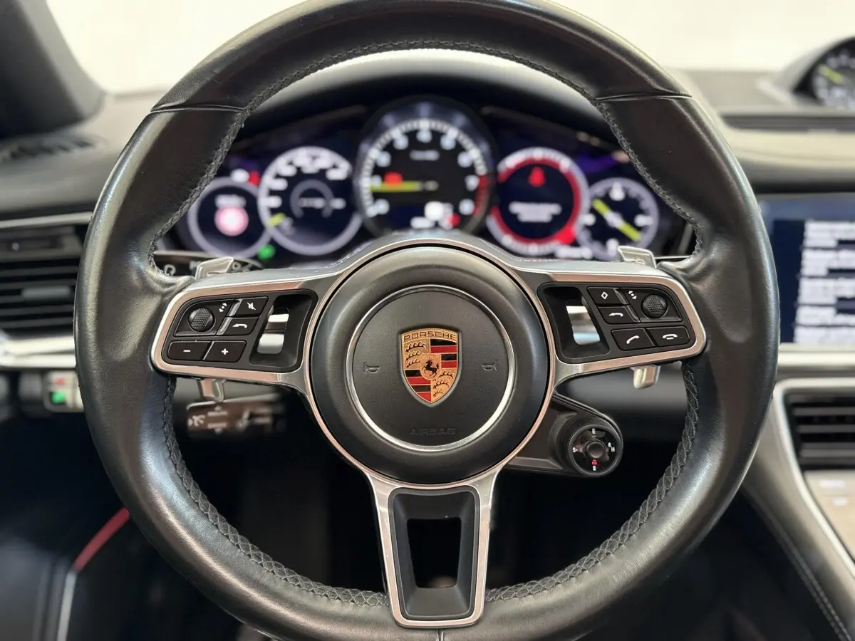 Volant cuir noir multifonctions de Porsche Panamera 4 E-Hybrid Sport Turismo, vue frontale rapprochée sur le tableau de bord.