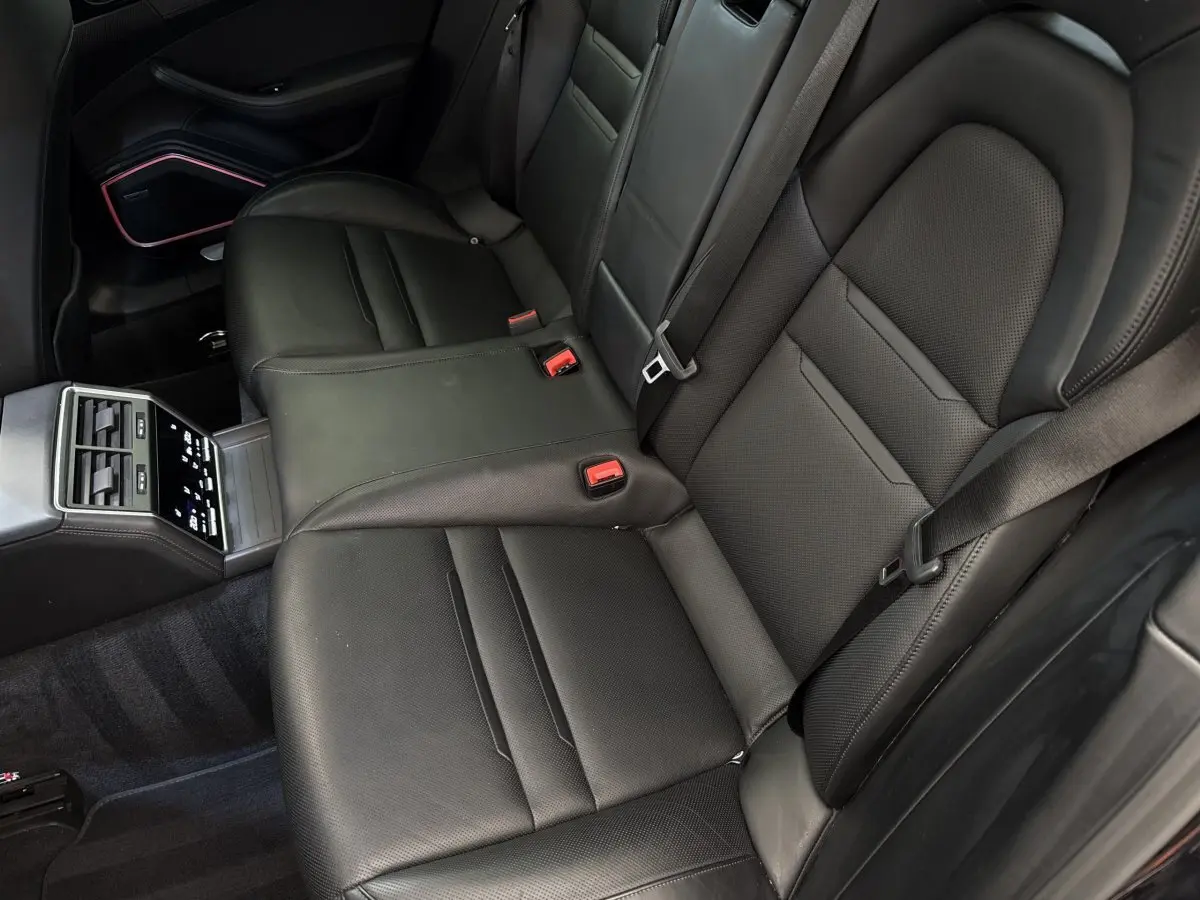 Vue intérieure des sièges arrière noirs en cuir de la Porsche Panamera 4 E-Hybrid Sport Turismo 2018 avec console centrale tactile.