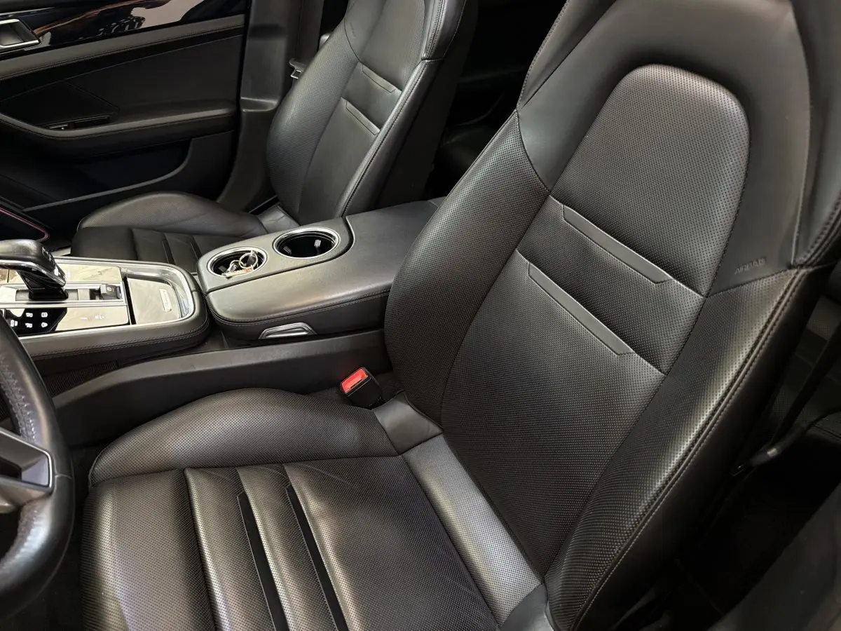 Gros plan sur les sièges avant en cuir noir perforé et la console centrale de la Porsche Panamera 4 E-Hybrid Sport Turismo 2018.