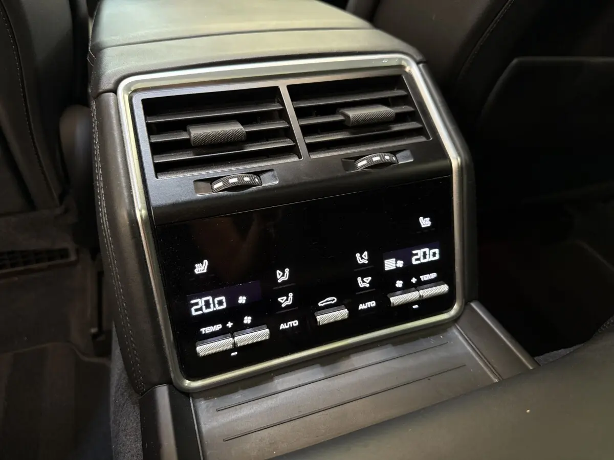 Détail de la console arrière noire de la Porsche Panamera 4 E-Hybrid avec commandes tactiles de climatisation et aérateurs.