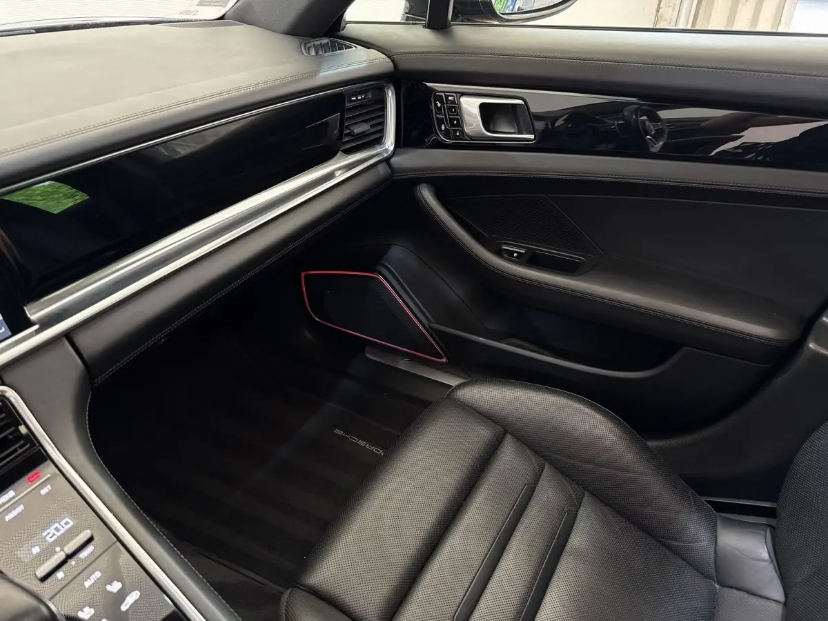 Intérieur noir de la Porsche Panamera 4 E-Hybrid Sport Turismo 2018, vue côté passager avant avec tableau de bord épuré.