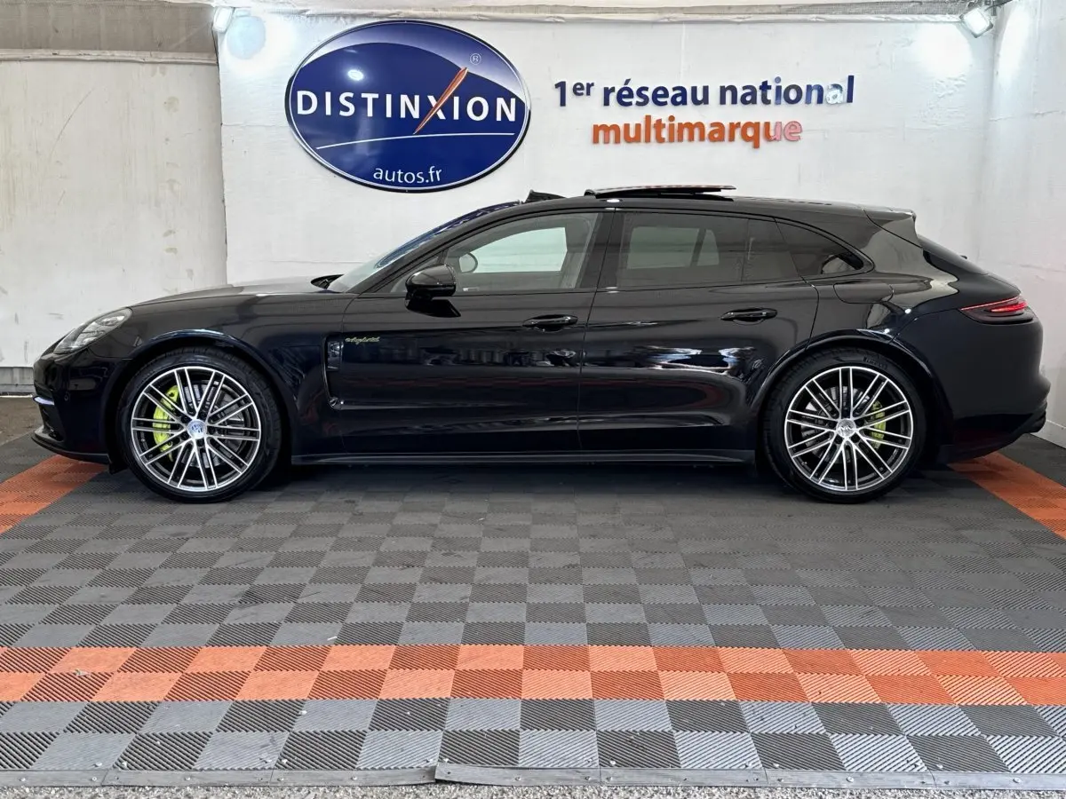 Vue de profil côté gauche d'une Porsche Panamera 4 E-Hybrid Sport Turismo noire avec jantes alliage et étriers verts.