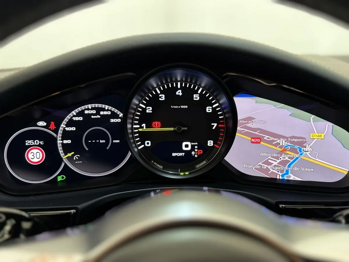 Vue rapprochée du tableau de bord numérique de la Porsche Panamera 4 E-Hybrid Sport Turismo avec affichage de la navigation et compte-tours.