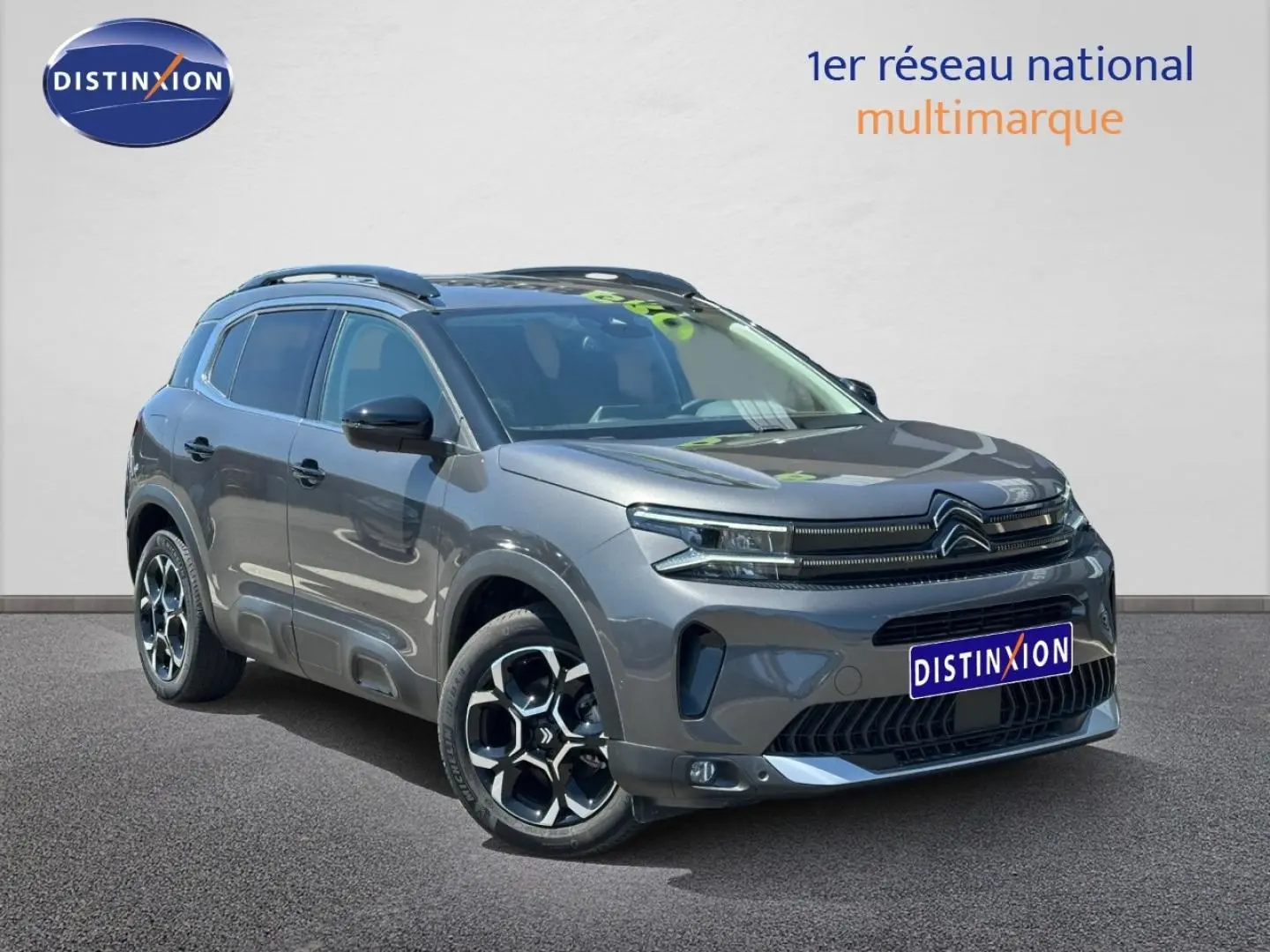Citroën C5 Aircross gris Platinium vue 3/4 avant droit avec jantes alu et barres de toit visibles.
