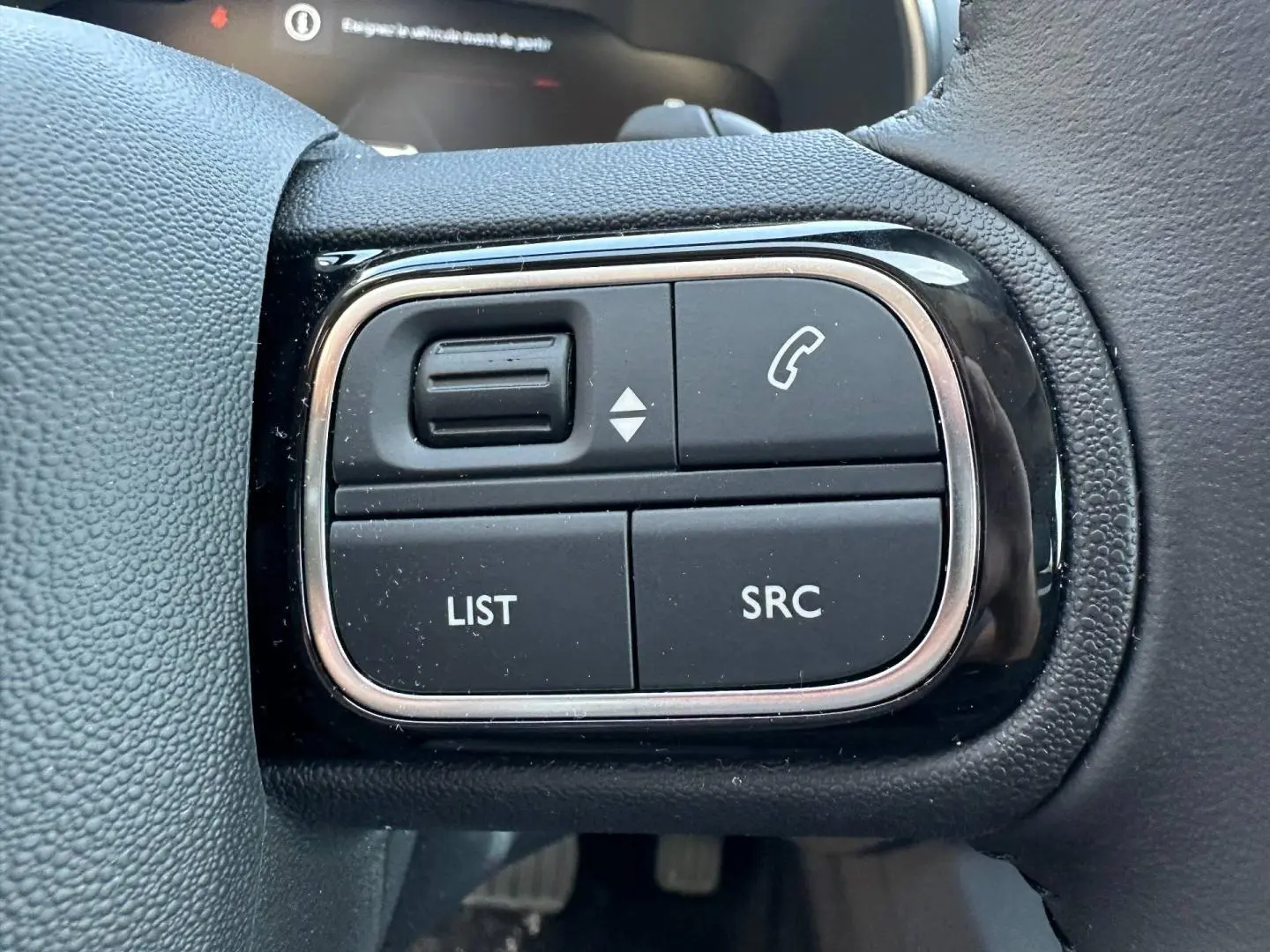 Gros plan sur les commandes noires du volant cuir du Citroën C5 Aircross 2025, finition Gris Platinium.