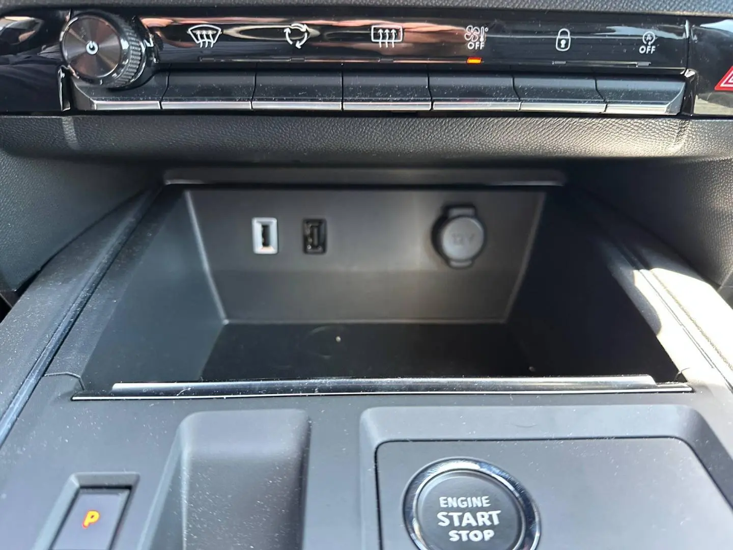Gros plan intérieur sur la console centrale noire avec bouton démarrage, prises USB et prise 12V du Citroën C5 Aircross.