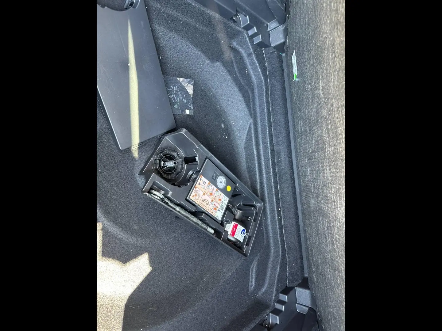 Gros plan sur le coffre du Citroën C5 Aircross 2025 gris Platinium, montrant le kit de réparation pneus intégré.