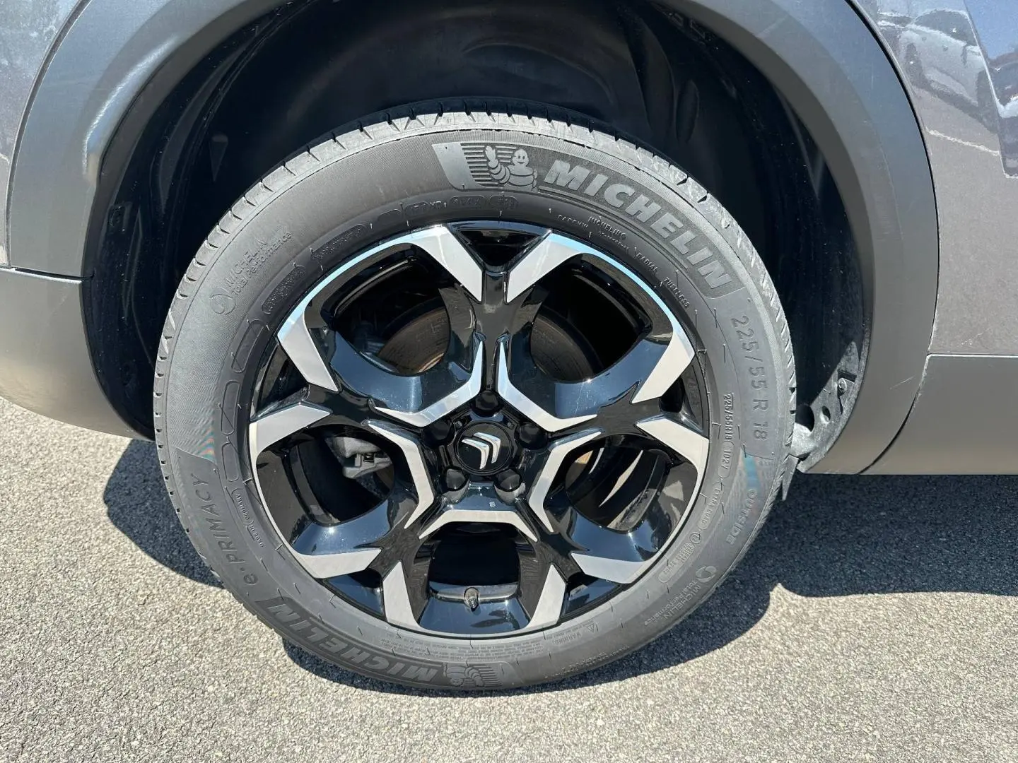Gros plan sur la jante alu noire et argent avec pneu Michelin du côté droit d’un Citroën C5 Aircross gris Platinium.