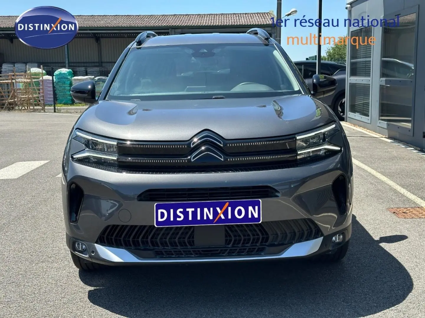 Vue frontale d'un Citroën C5 Aircross 2025 gris Platinium avec calandre distinctive et barres de toit visibles.