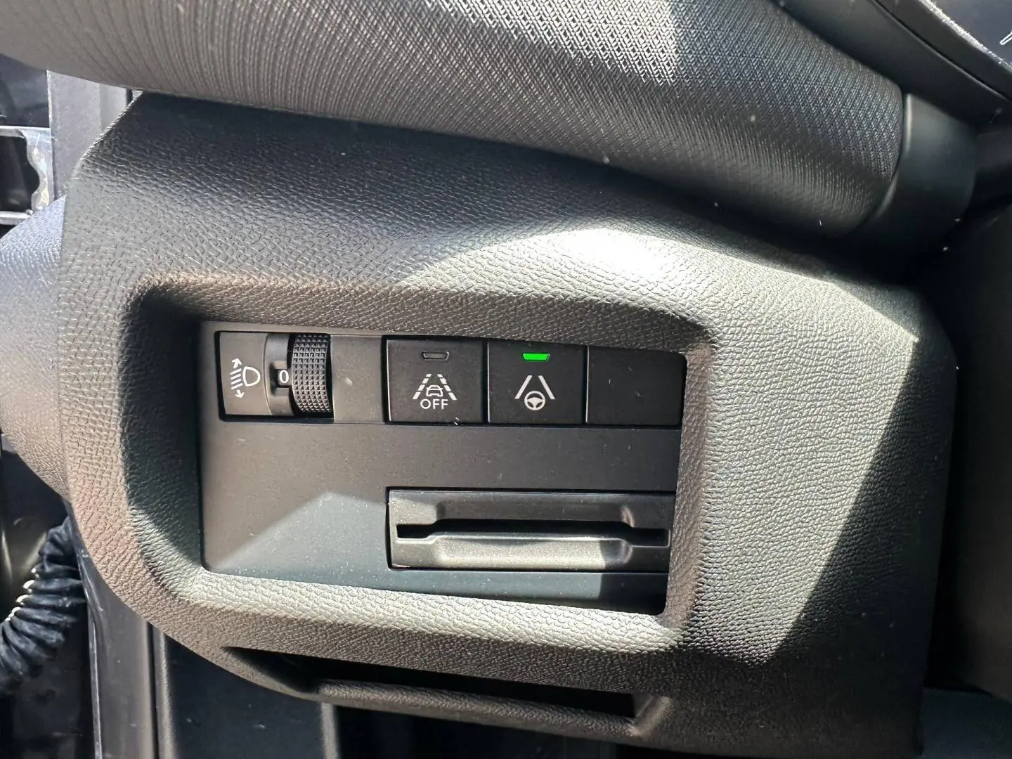 Gros plan sur les commandes d'assistance à la conduite à gauche du volant dans un Citroën C5 Aircross gris Platinium.
