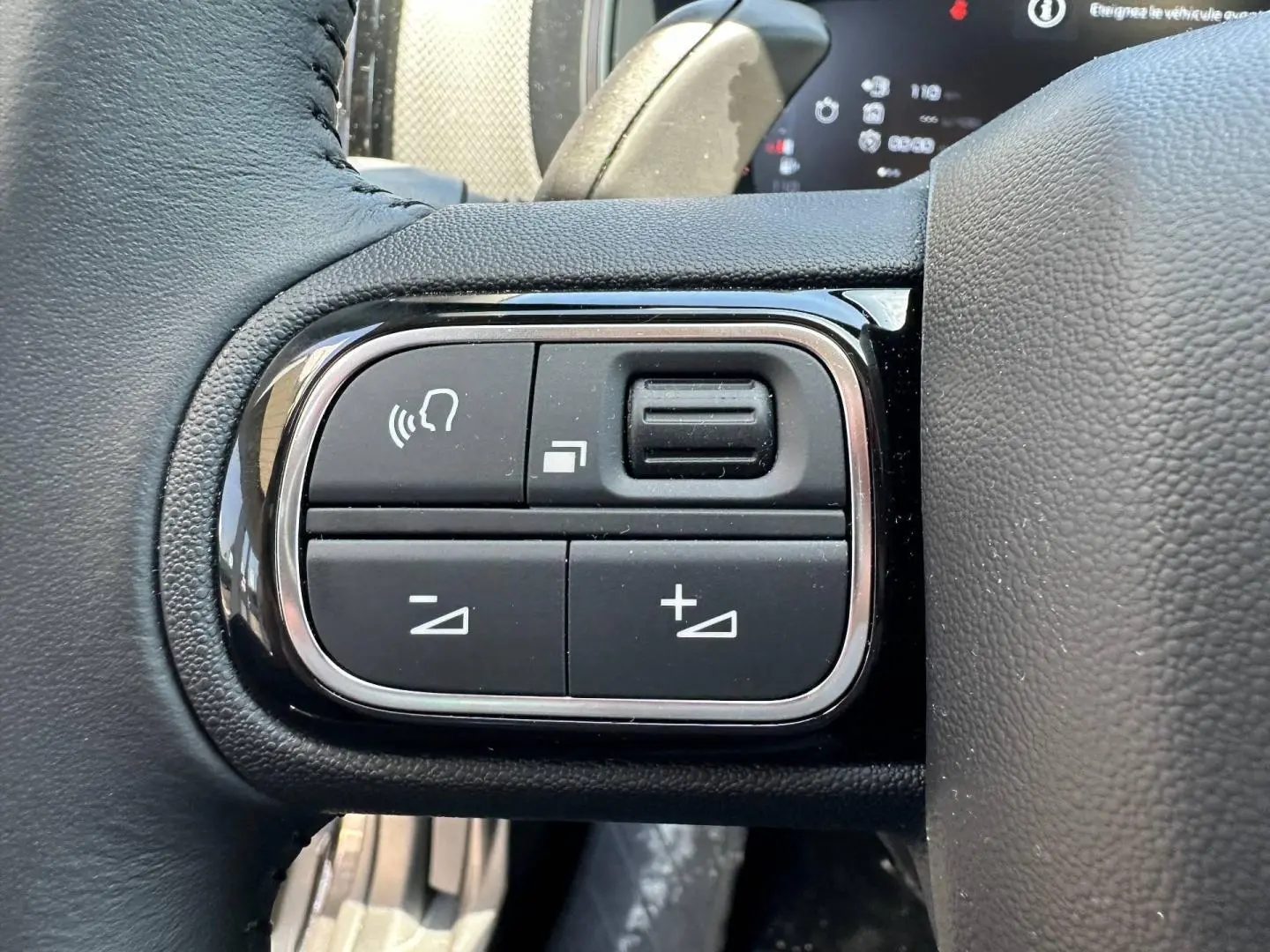 Gros plan sur les commandes vocales et de volume sur le volant cuir noir du Citroën C5 Aircross 2025.