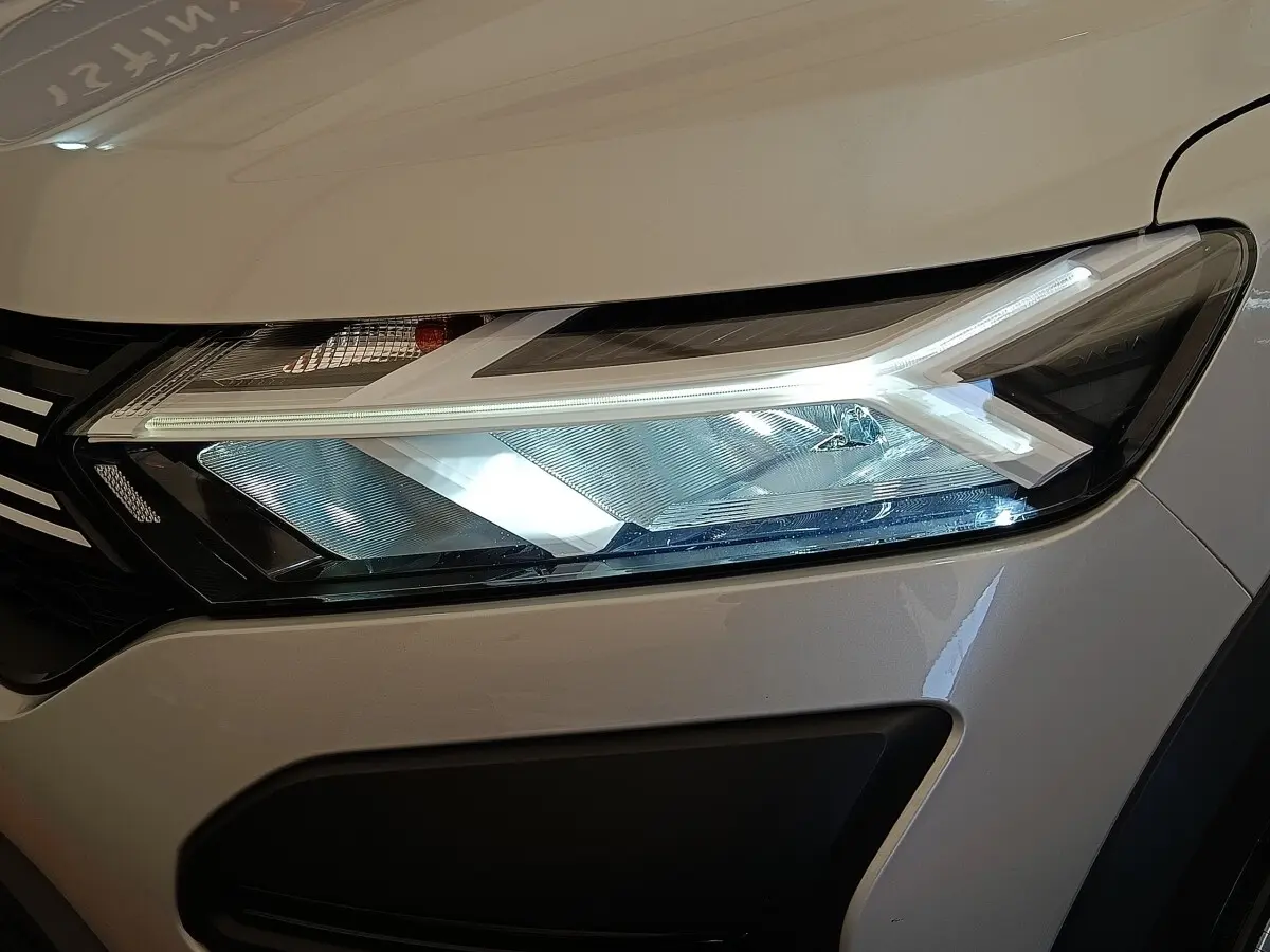 Gros plan sur le phare avant droit LED d'une Dacia Sandero gris clair 2023, soulignant son design moderne.