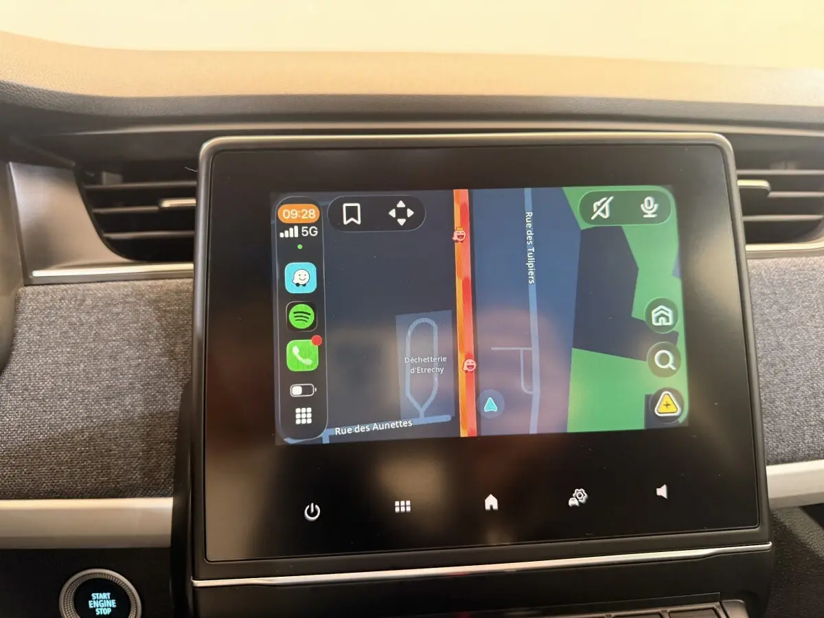 Écran tactile central de la Renault ZOE noire 2024 affichant la navigation avec carte en mode jour.
