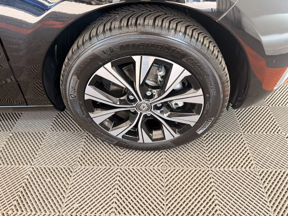 Gros plan sur la roue avant droite noire de la Renault ZOE 2024 avec jante alliage bicolore et pneu Michelin.
