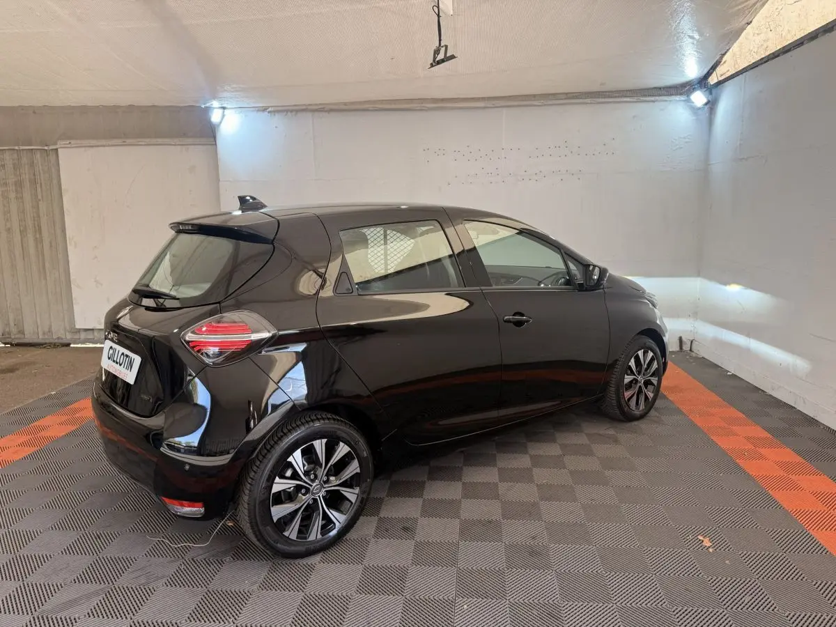 Renault ZOE noire vue 3/4 arrière droit dans un garage, avec jantes alliage et feux arrière LED distinctifs.