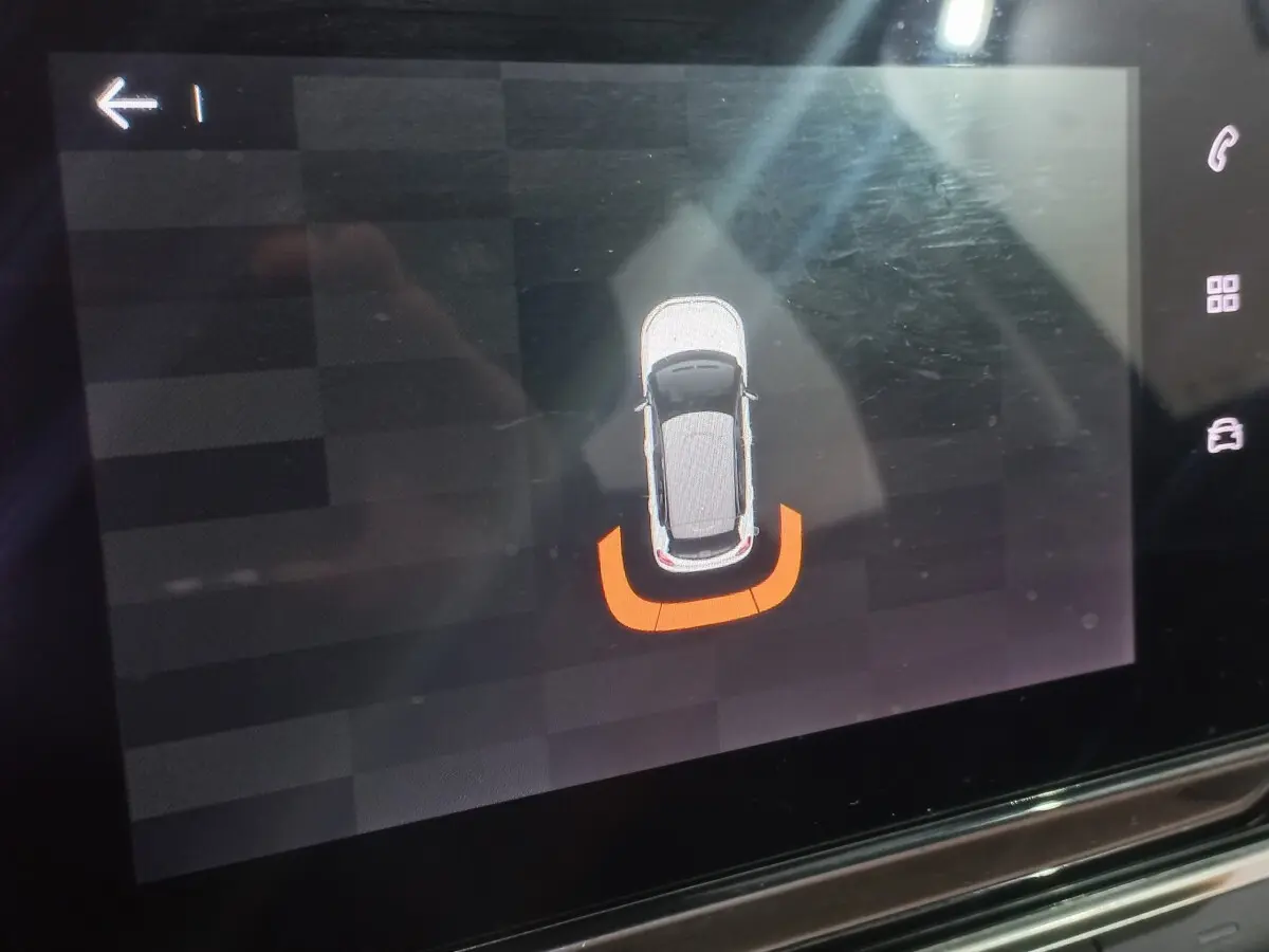 Affichage tactile intérieur montrant la silhouette d'une Citroën C3 noire avec alerte de proximité arrière en orange.