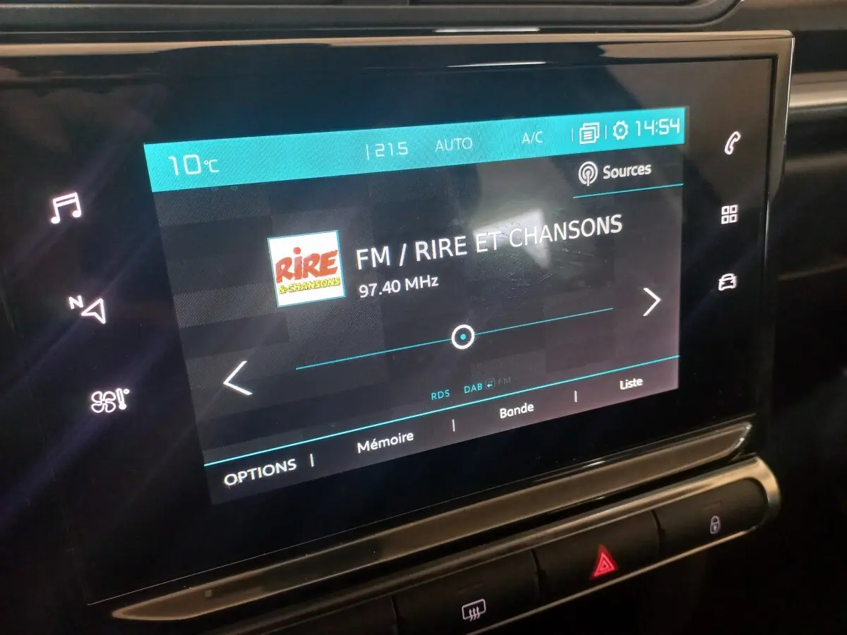 Écran tactile central de la Citroën C3 2024 affichant la radio FM sur fond noir intérieur.