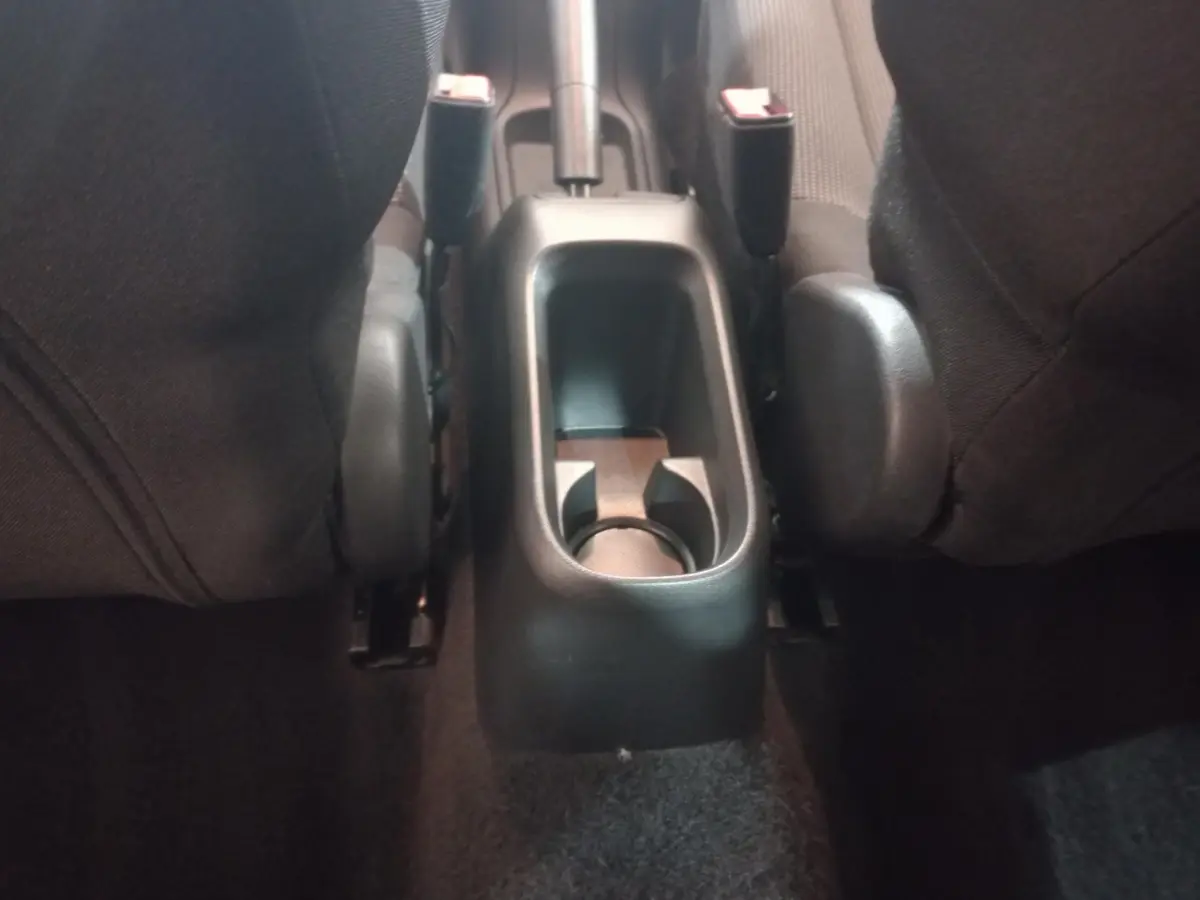 Vue rapprochée de la console centrale arrière noire entre les sièges avant du Citroën C3 2024.