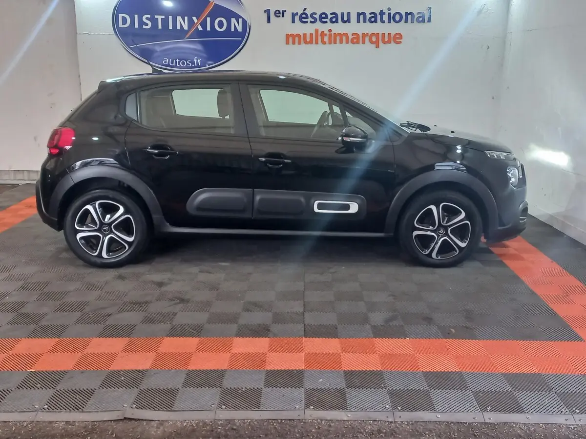 Citroën C3 noire vue de profil côté gauche, avec protections latérales caractéristiques et jantes stylisées.