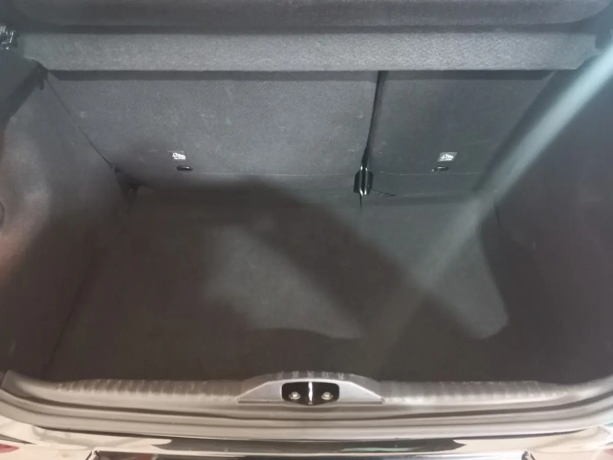 Coffre ouvert vu de dessus de la Citroën C3 noire 2024, montrant l’espace de chargement et la banquette arrière rabattable.