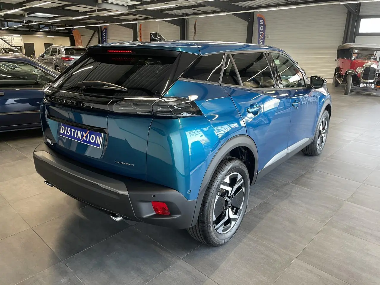 Peugeot 2008 bleu en vue 3/4 arrière droit, avec feux arrière à LED et jantes alliage 17'' bi-ton.