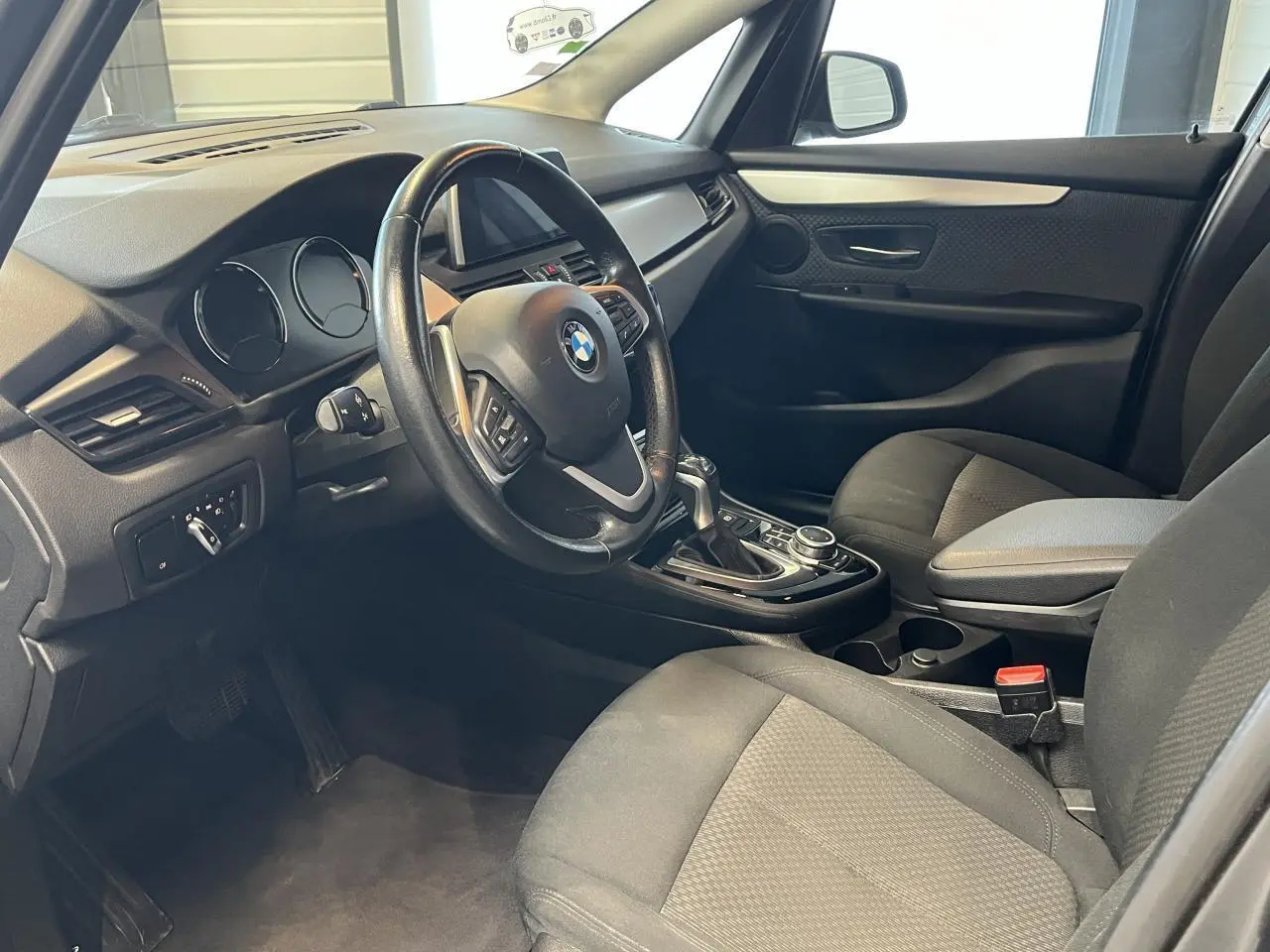 Intérieur avant droit de la BMW Série 2 225xe Active Tourer 2018, avec volant multifonction et sellerie noire.