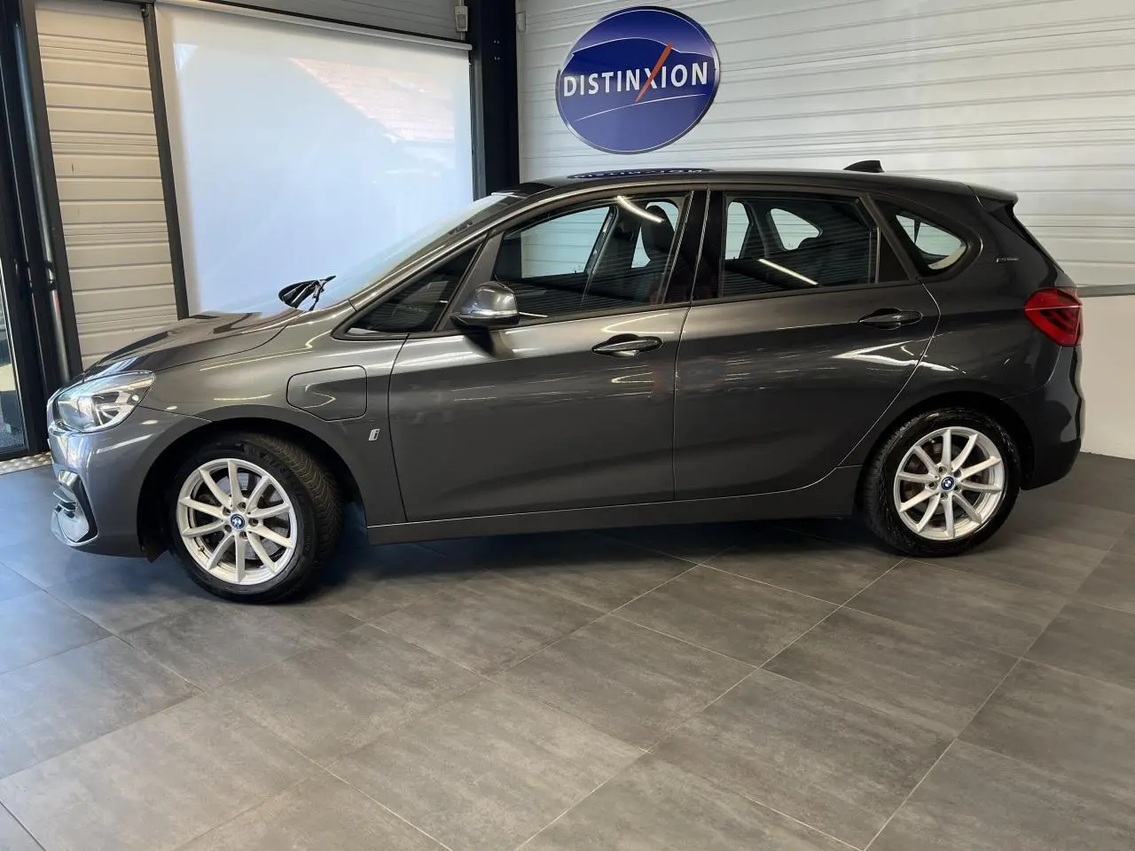 Profil côté gauche d'une BMW Série 2 Active Tourer gris métallisé de 2018, hybride essence avec jantes argentées.