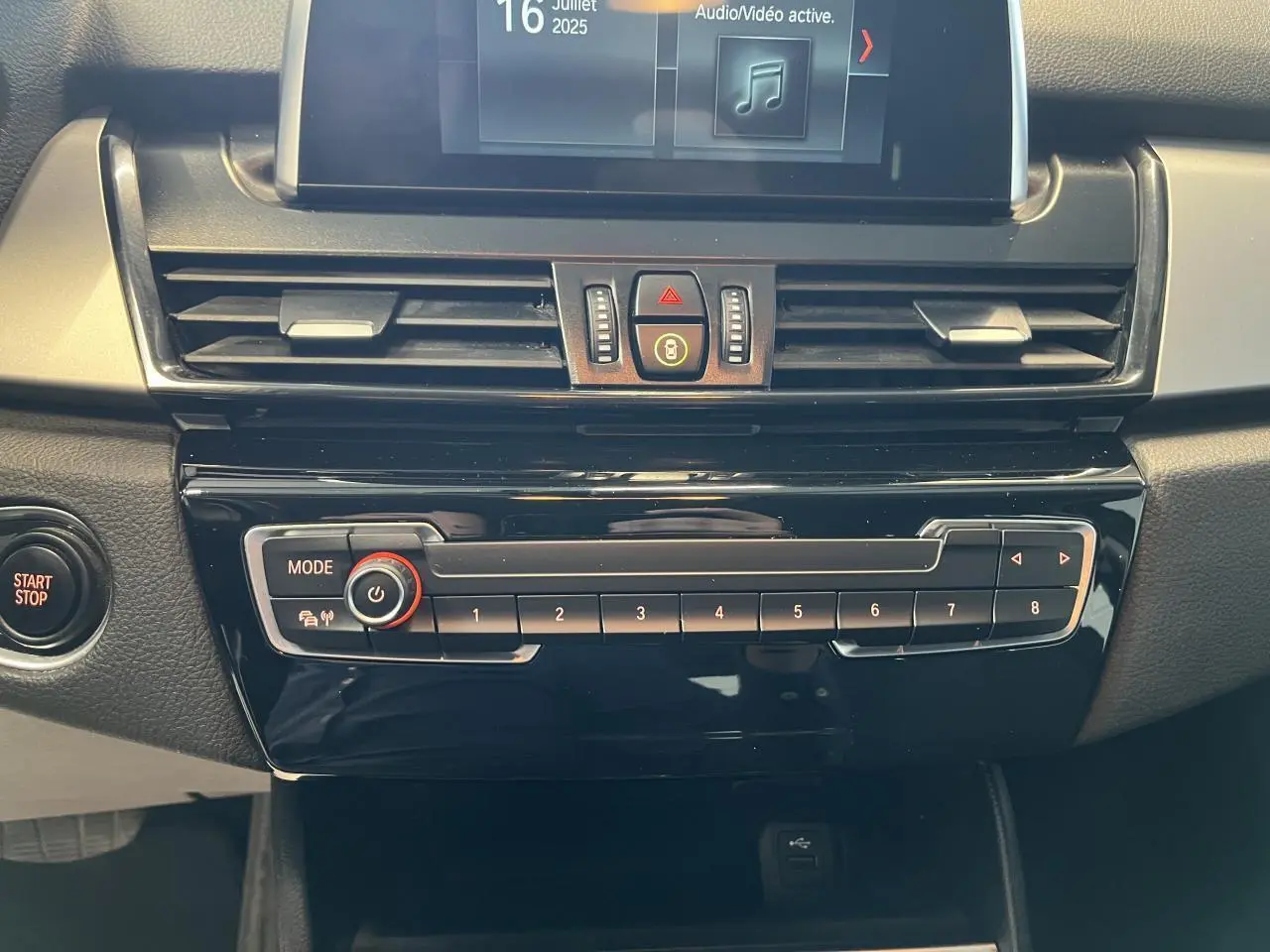 Vue rapprochée de la console centrale noire du BMW Série 2 225xe Active Tourer 2018 avec écran et commandes audio.