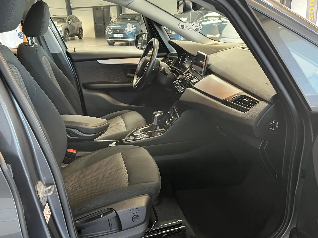 Intérieur de la BMW Série 2 225xe Active Tourer gris, vue côté gauche sur les sièges et le tableau de bord moderne.