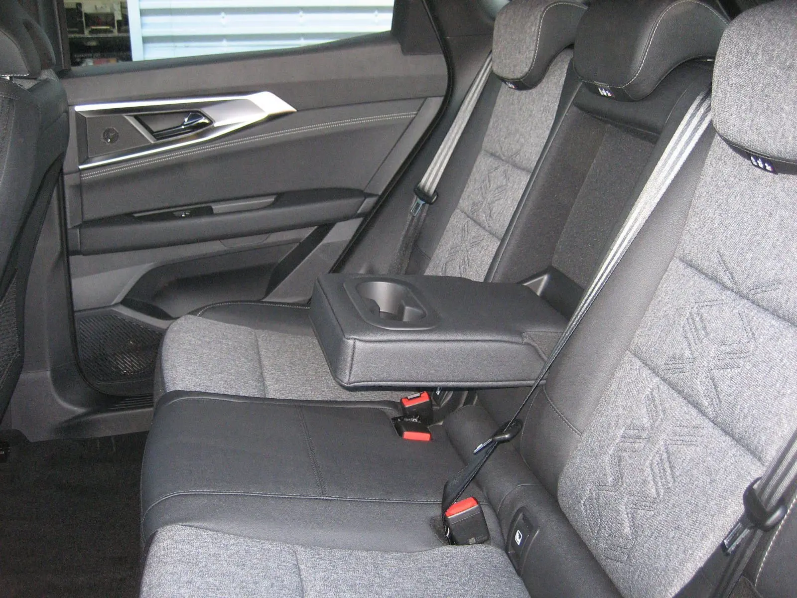 Vue latérale gauche de la banquette arrière bicolore gris et noir avec accoudoir central déployé du Renault Austral 2025.