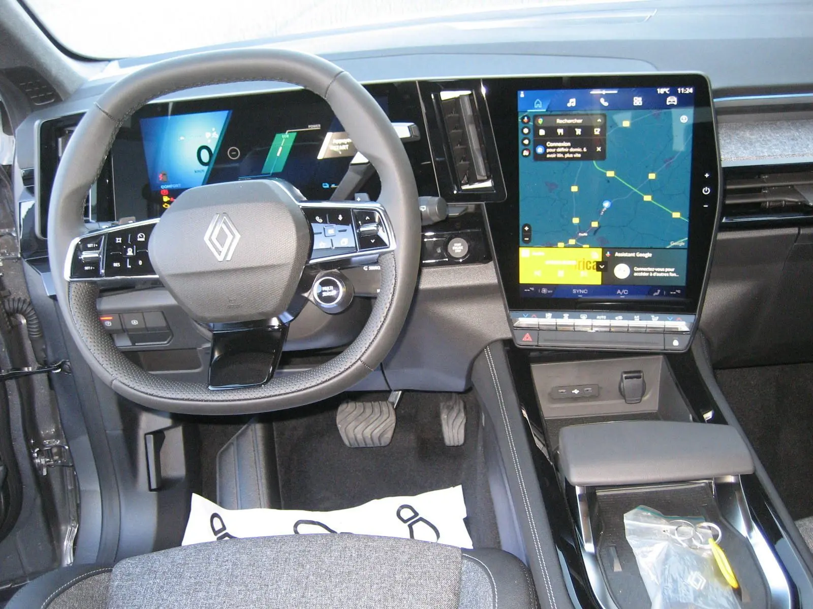 Vue intérieure du tableau de bord du Renault Austral gris schiste, avec écran tactile central et volant multifonction.