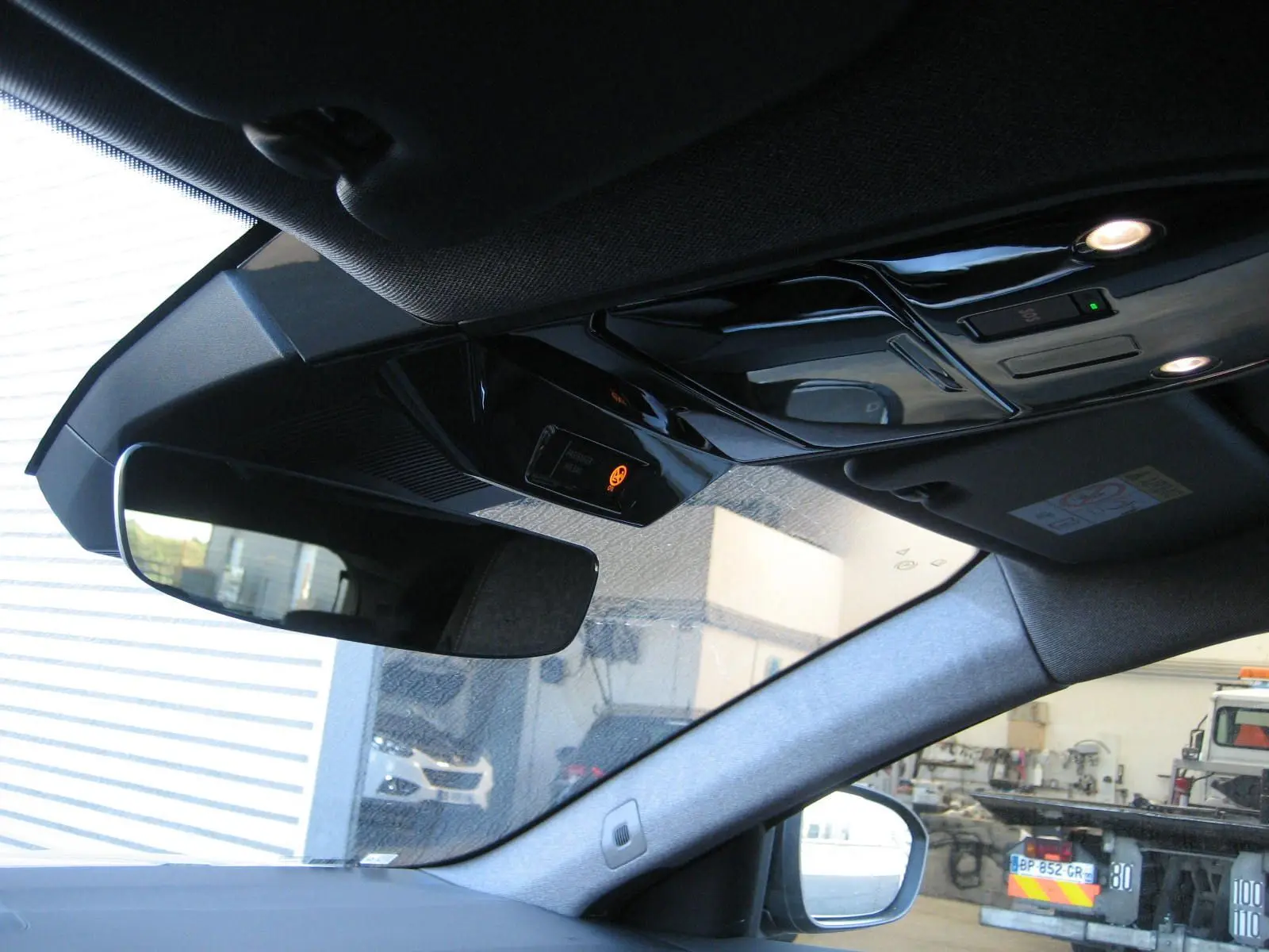 Vue intérieure du rétroviseur et plafonnier du Renault Austral gris schiste, avec éclairage et capteurs visibles.