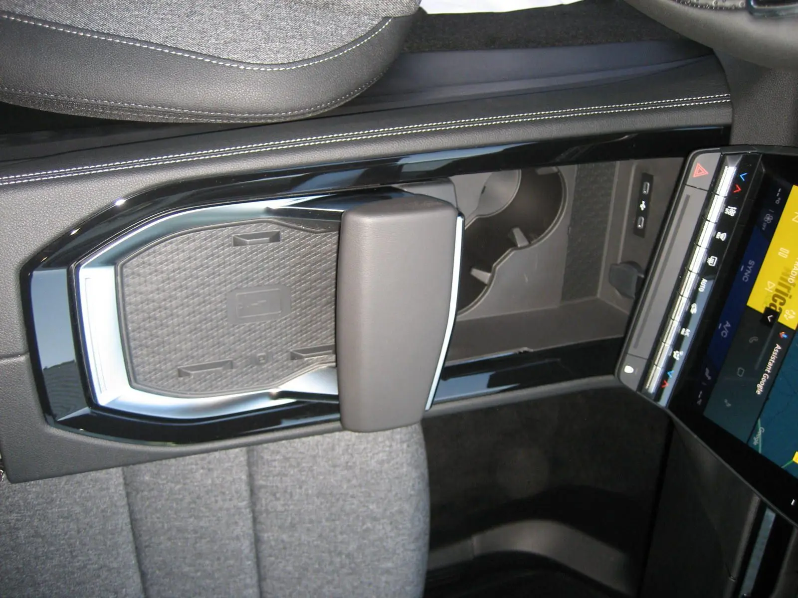 Vue rapprochée de la console centrale noire et grise avec accoudoir et écran tactile du Renault Austral 2025.