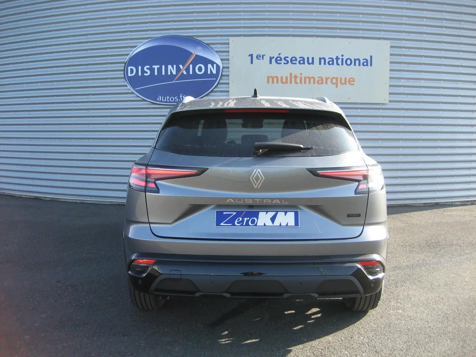 Vue arrière d'un Renault Austral gris schiste 2025 avec feux LED étirés et logo central lumineux.