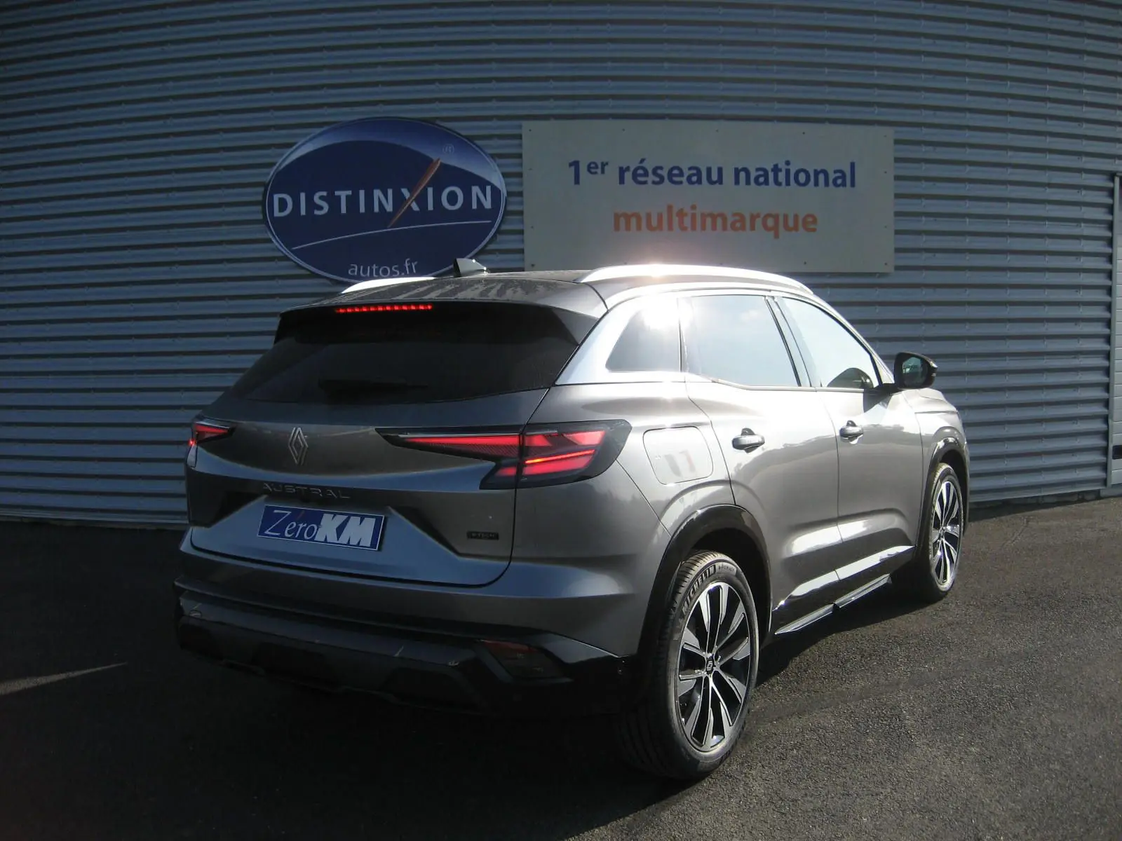 Vue 3/4 arrière droite du Renault Austral gris schiste avec feux LED et jantes bi-ton visibles au soleil.