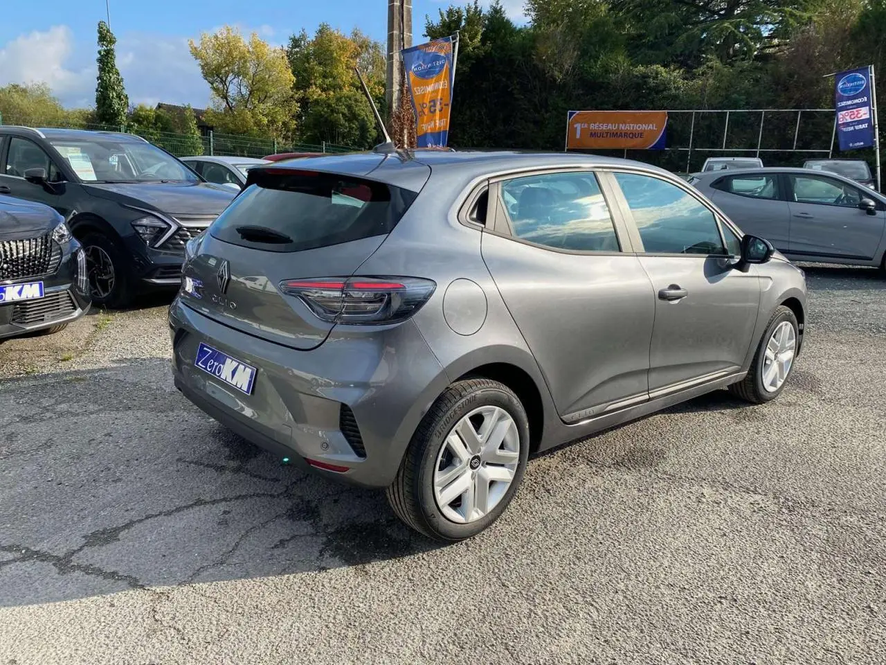Renault Clio 2025 gris schiste vue 3/4 arrière droit, avec feux LED et jantes alliage visibles en extérieur.