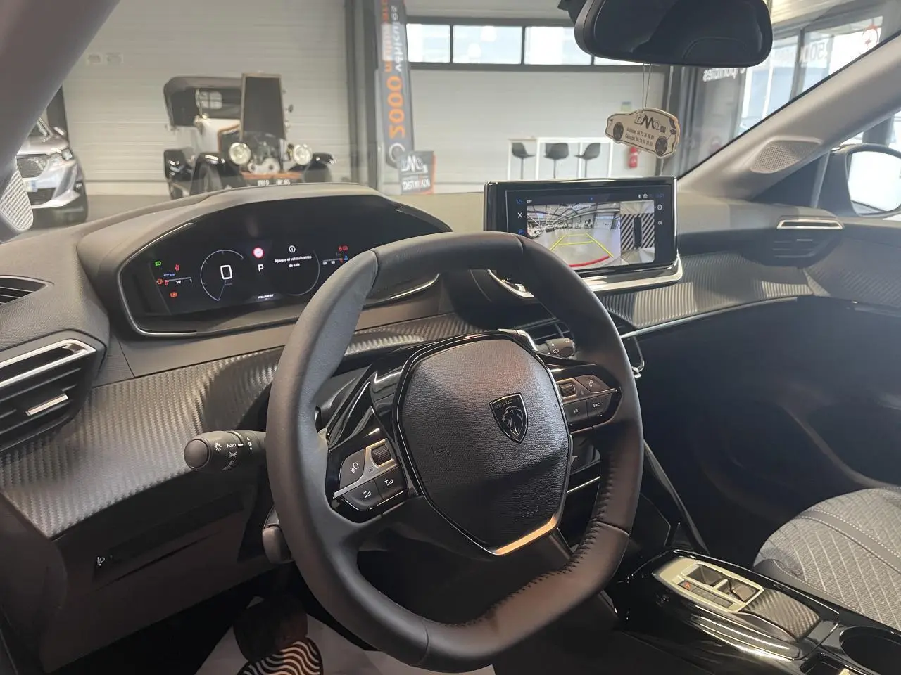 Vue intérieure côté conducteur du Peugeot 208 2025, volant compact cuir et tableau de bord numérique avec écran tactile.
