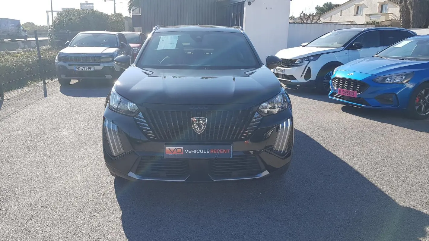 Peugeot 2008 Hybrid 145 Allure noir vue de face, mettant en valeur la calandre distinctive et les feux LED verticaux.