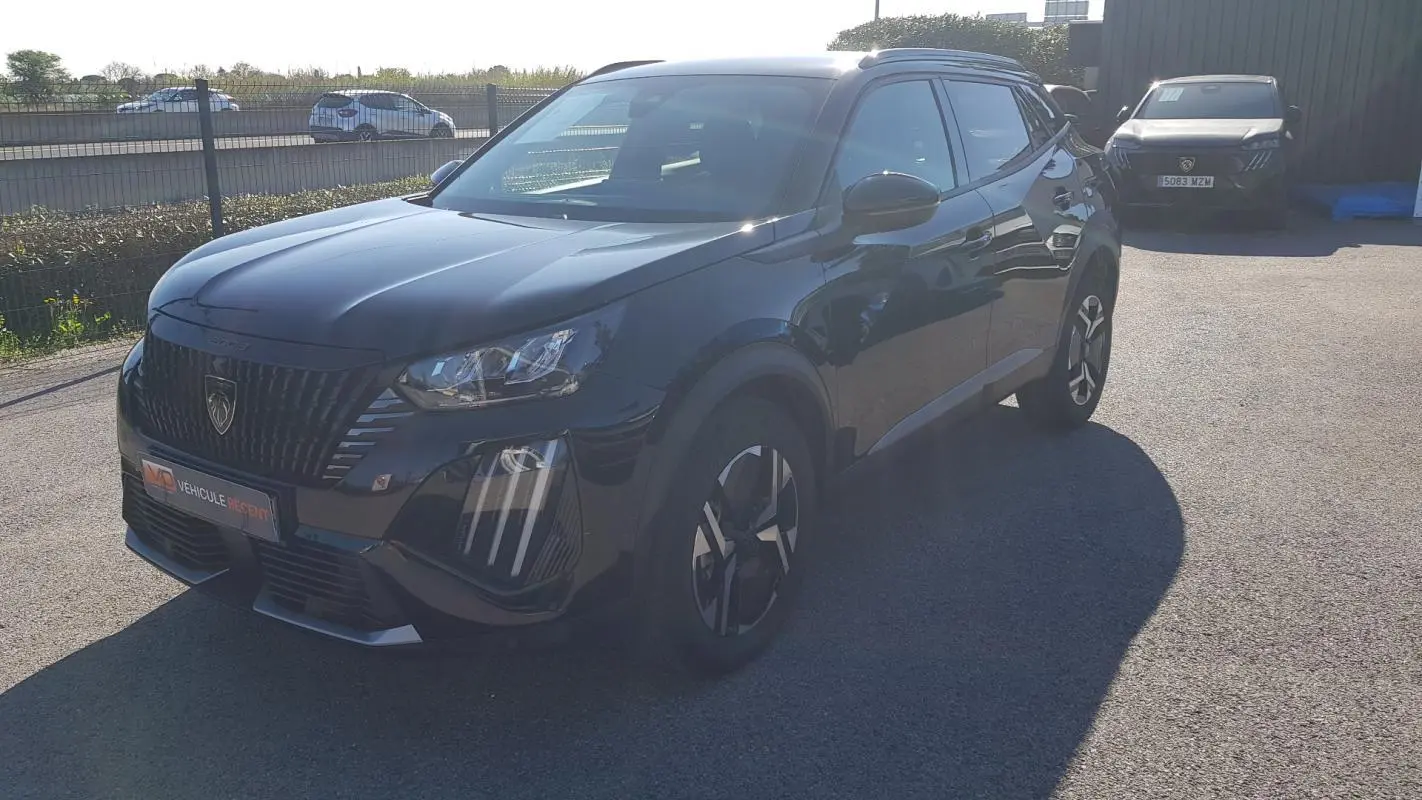 Peugeot 2008 Hybrid 145 Allure noir en 3/4 avant droit, avec jantes alliage 17 pouces et calandre distinctive.
