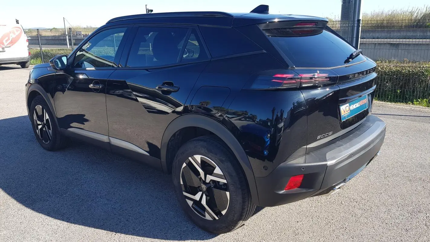 Vue 3/4 arrière droite d’un Peugeot 2008 Hybrid 145 noir avec jantes alliage 17 pouces et vitres teintées.
