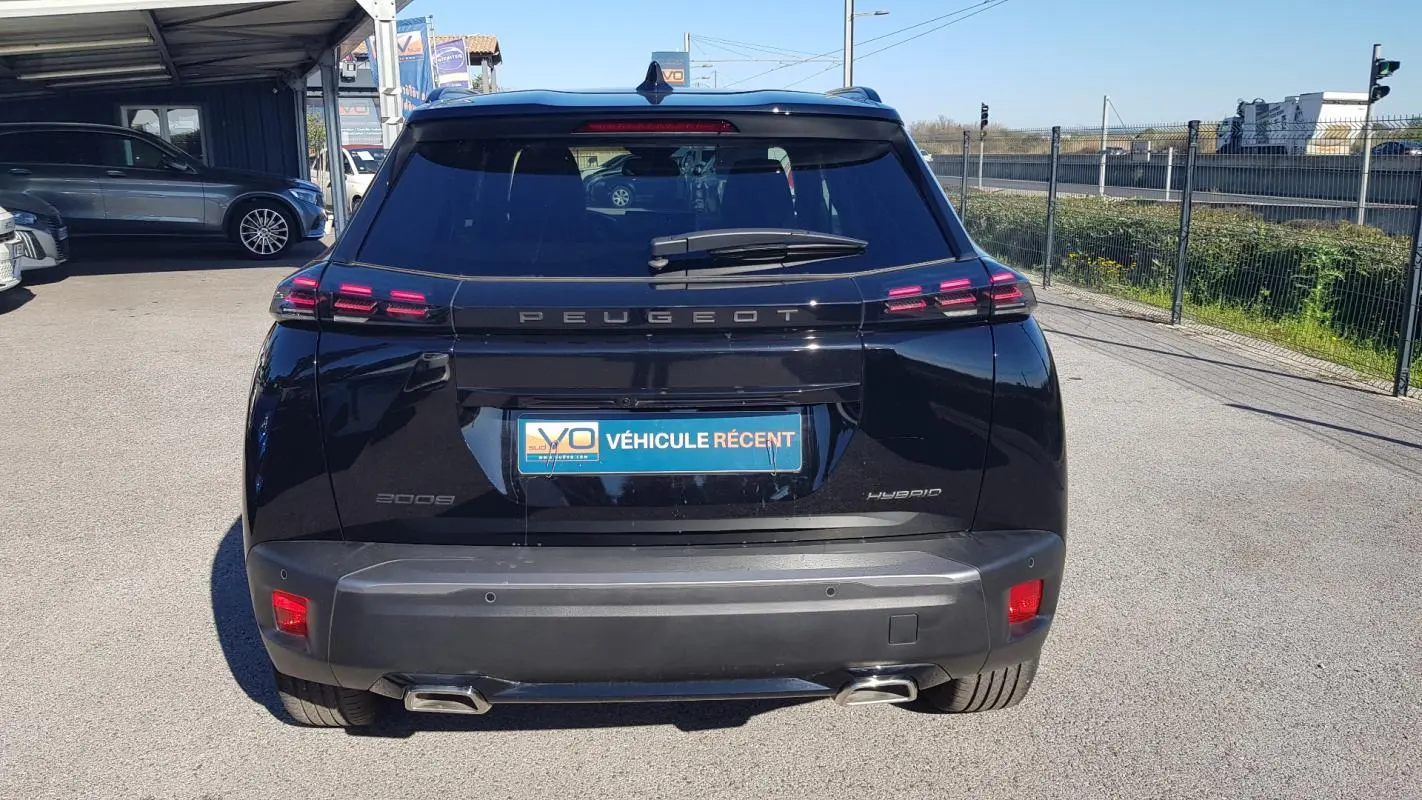 Vue arrière d'un Peugeot 2008 Hybrid noir de 2025 avec feux LED et double sortie d'échappement visible.