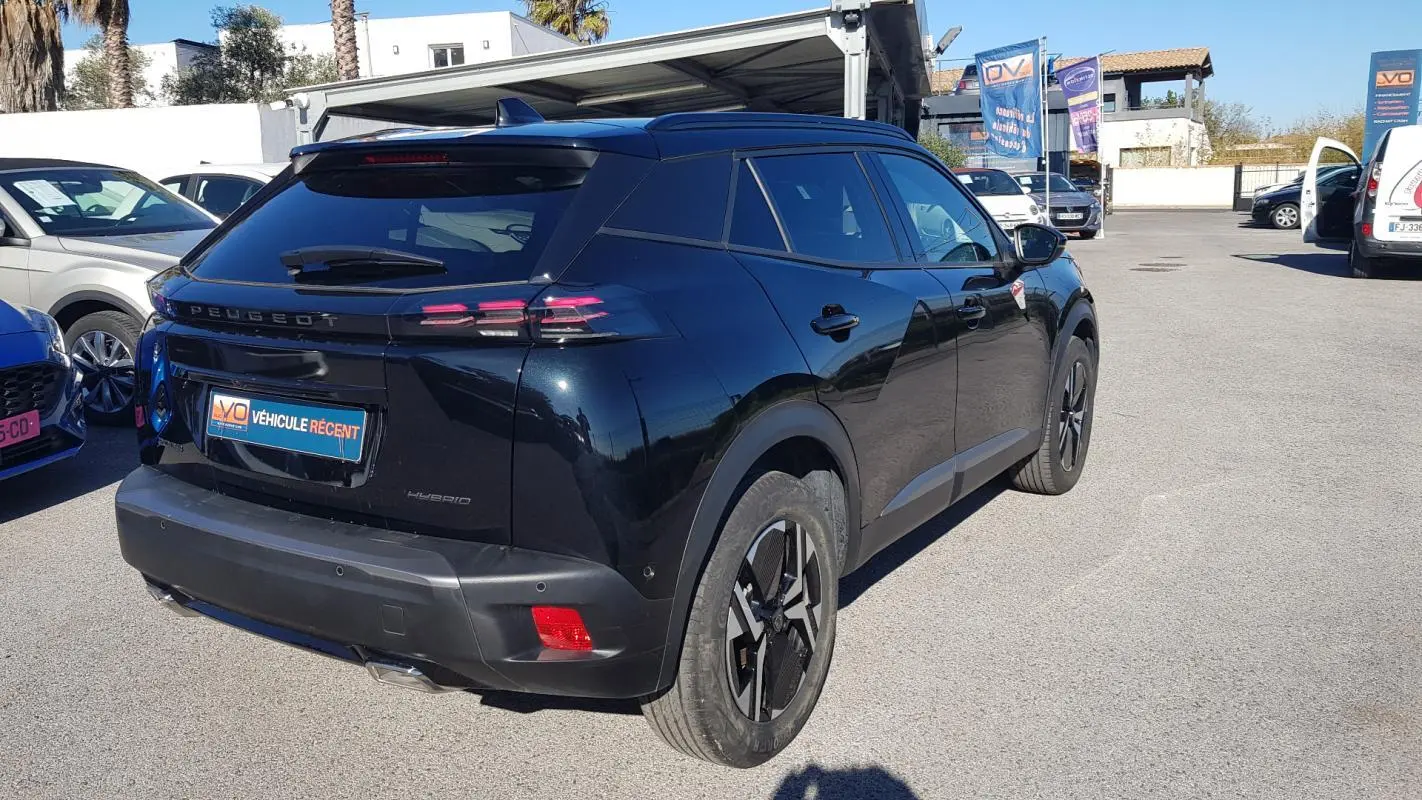 Vue 3/4 arrière droite d’un Peugeot 2008 Hybrid 145 noir avec jantes alliage 17 pouces et feux arrière LED distinctifs.