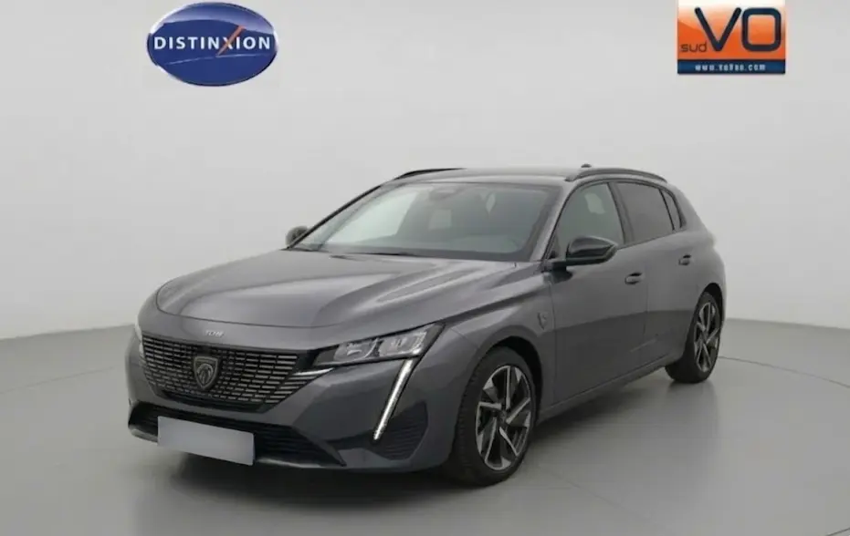 Peugeot 308 Hybrid gris vue 3/4 avant droit, jantes alliage 17 pouces et signature lumineuse verticale LED.