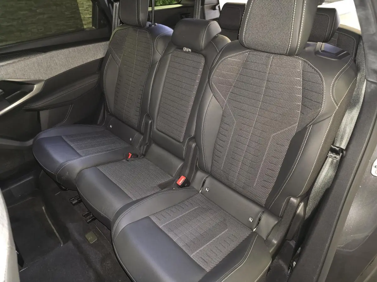 Vue intérieure côté droit sur la banquette arrière trois places en tissu et cuir noir du Peugeot 5008 gris 2025.