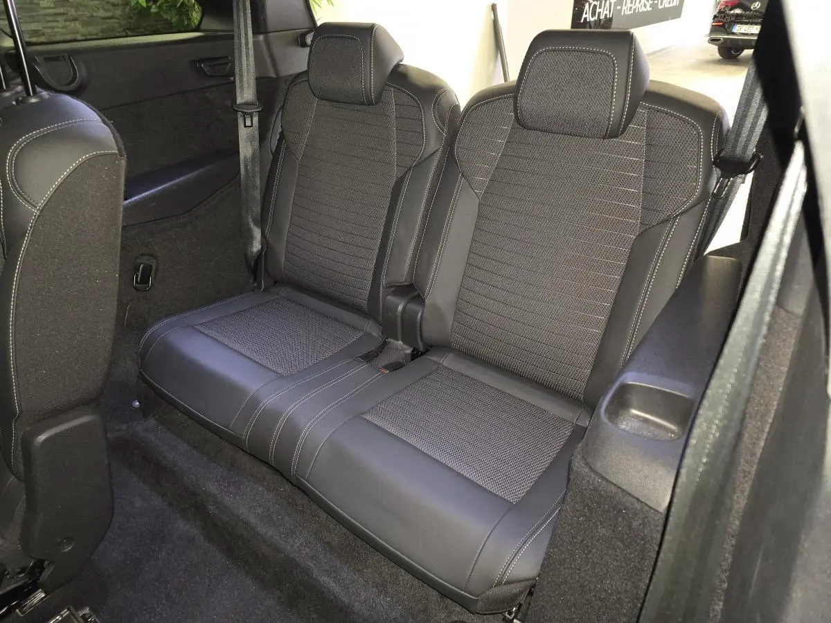 Vue intérieure du rang 3 du Peugeot 5008 gris 2025, montrant la banquette 2 places en tissu et cuir avec surpiqûres contrastées.