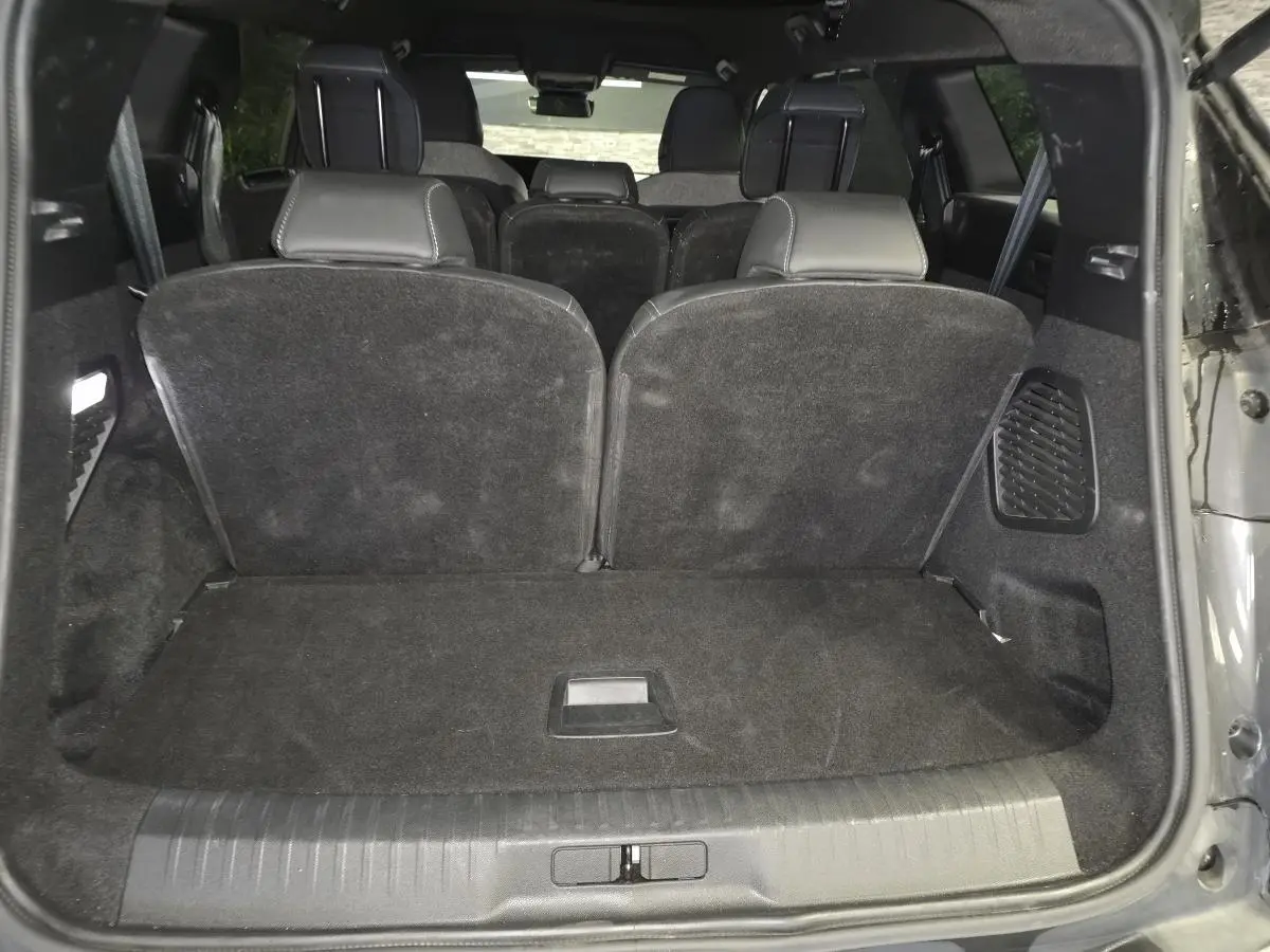 Vue arrière du coffre du Peugeot 5008 gris avec banquette troisième rangée relevée et intérieur noir.