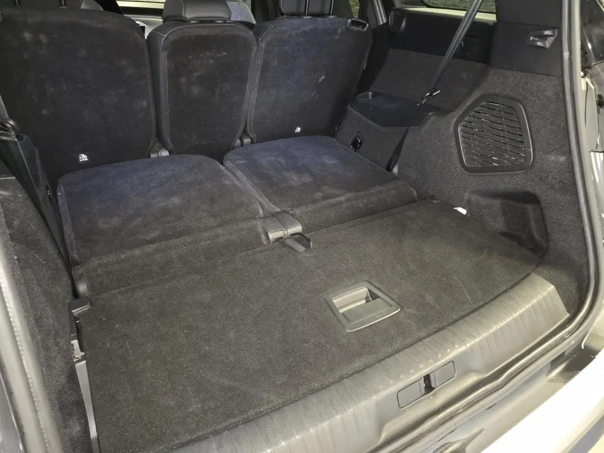 Coffre du Peugeot 5008 gris vu de l'arrière avec banquette arrière partiellement rabattue et espace de chargement plat.