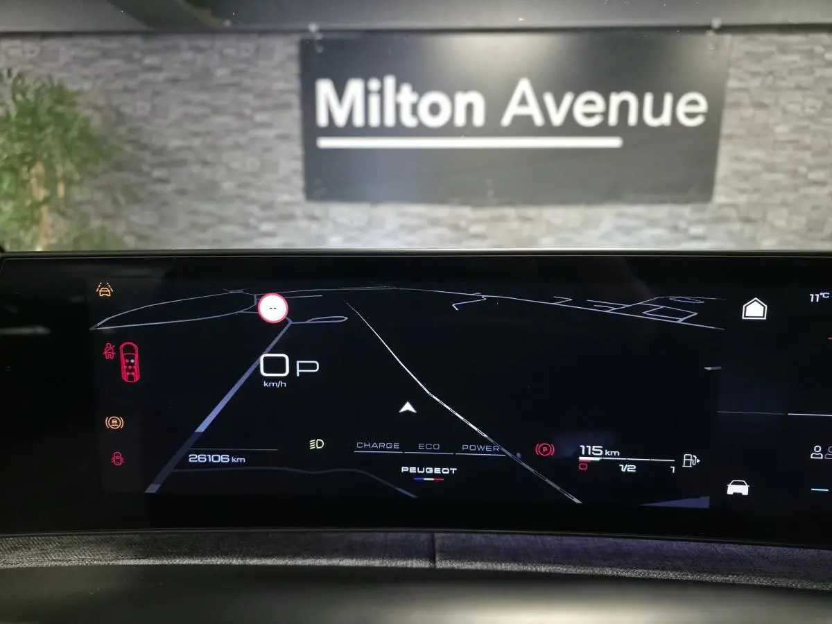 Affichage numérique du tableau de bord du Peugeot 5008 hybride, montrant la navigation et les informations de conduite.